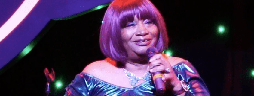 Singer performing on stage with microphone.